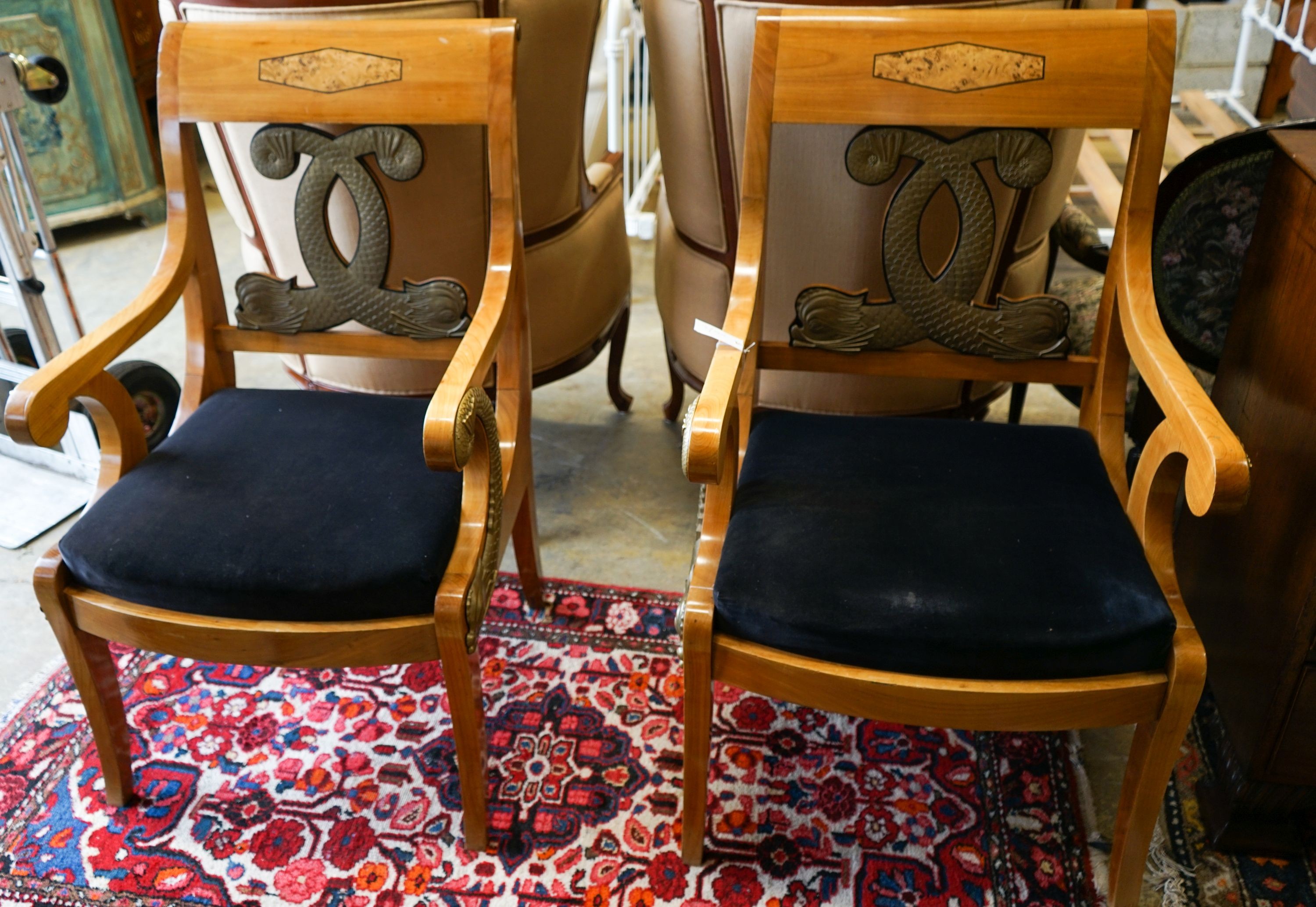 A pair of Empire style cherry elbow chairs with gilt metal dolphin mounts, width 65cm, depth 56cm, height 107cm